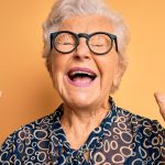 Senior Woman With Eyes Closed & Hands in Air