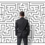 Man in Suit Back Turned Standing in Front of Maze